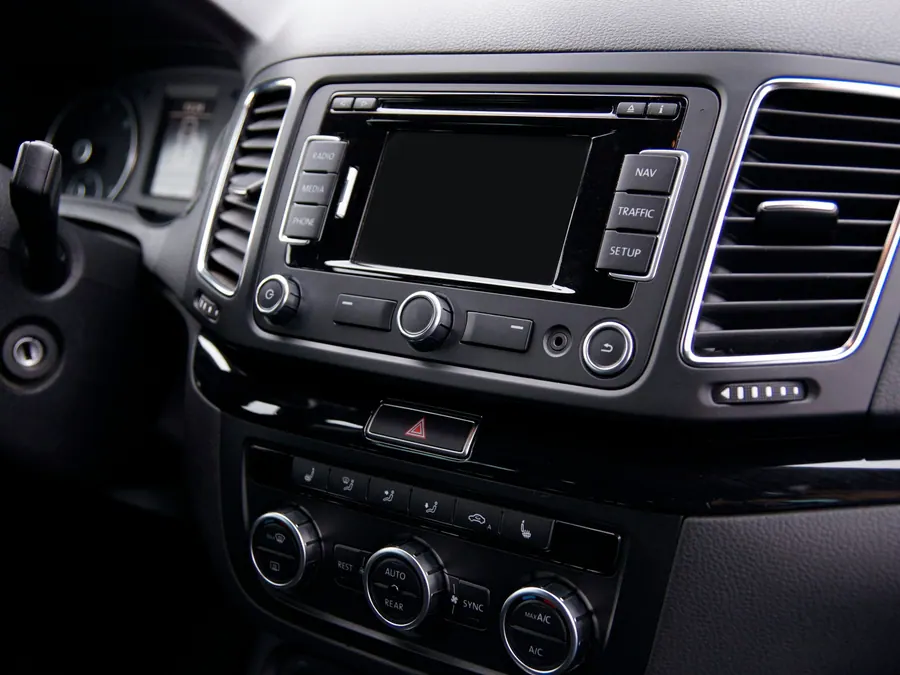 Factory car radio and climate controls in the dashboard of an older car