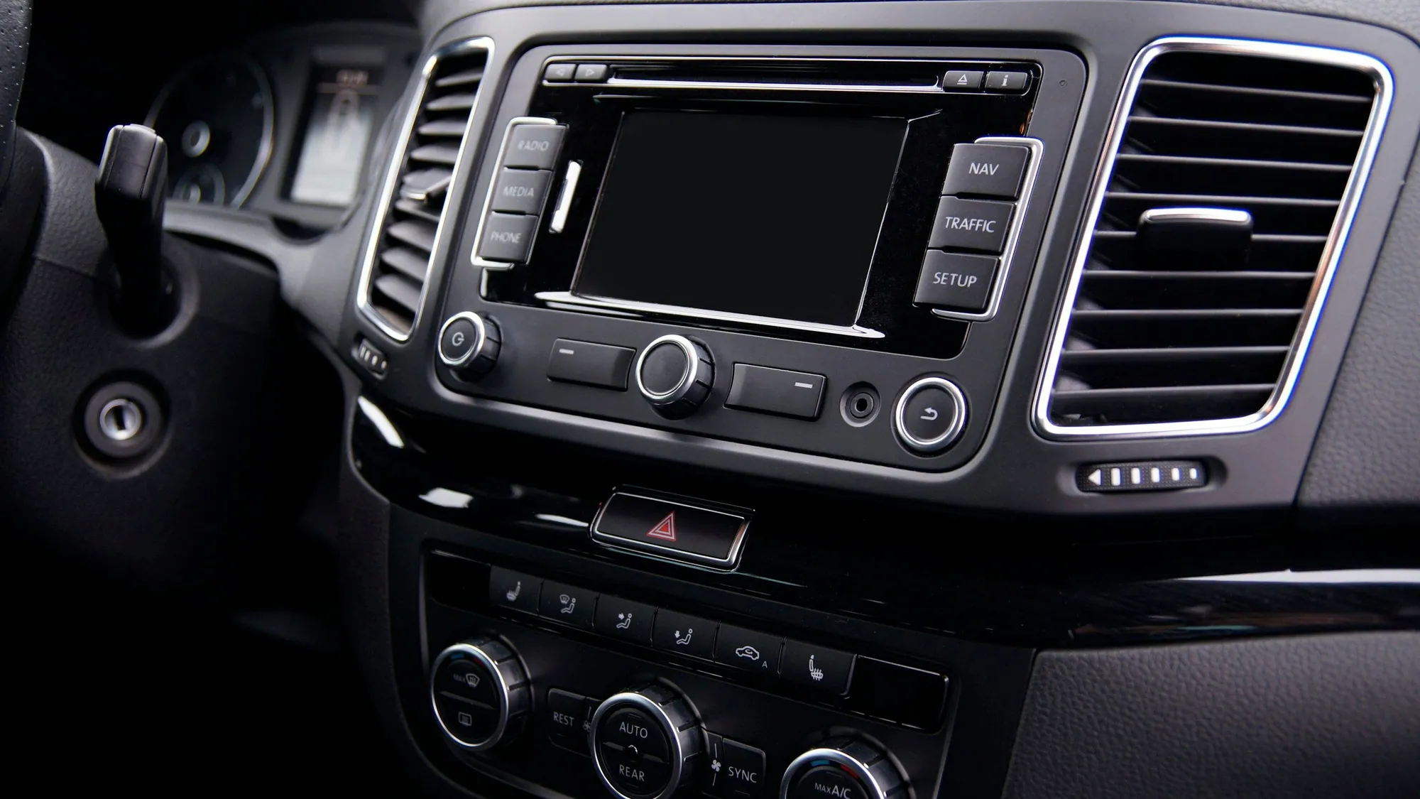 Factory car radio and climate controls in the dashboard of an older car